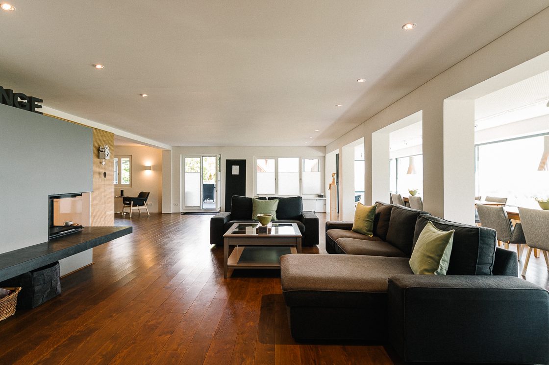 Gemütliche Kaminlounge mit Holzwänden, Holzboden und modernen Möbeln.